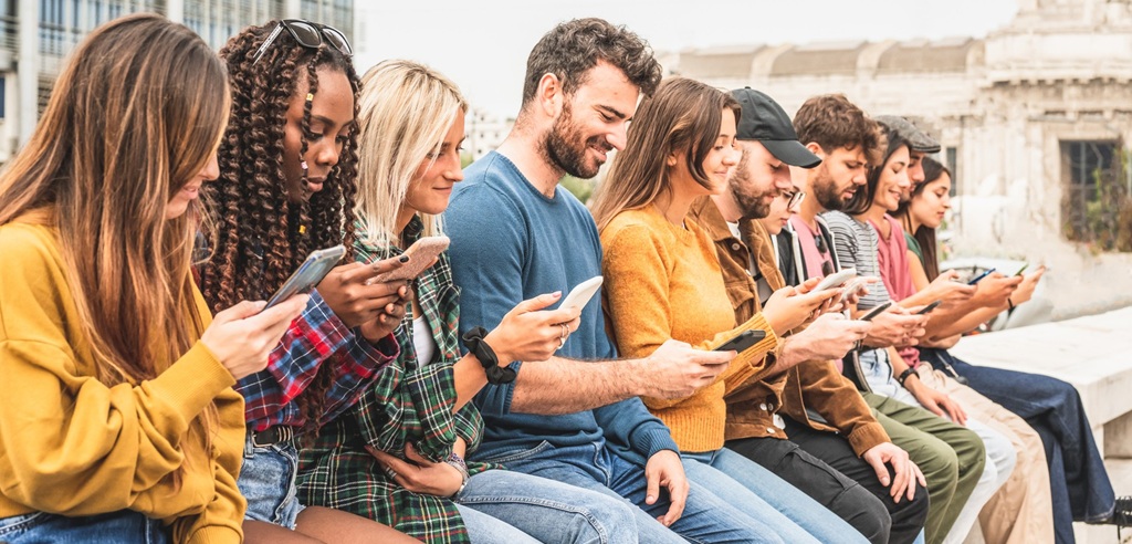 Folk på stribe, der kigger på deres mobiltelefoner