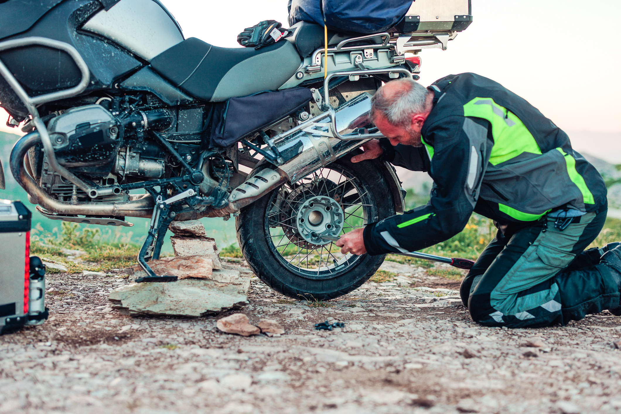 En mand, der er ved at reparere dækket på hans motorcykel