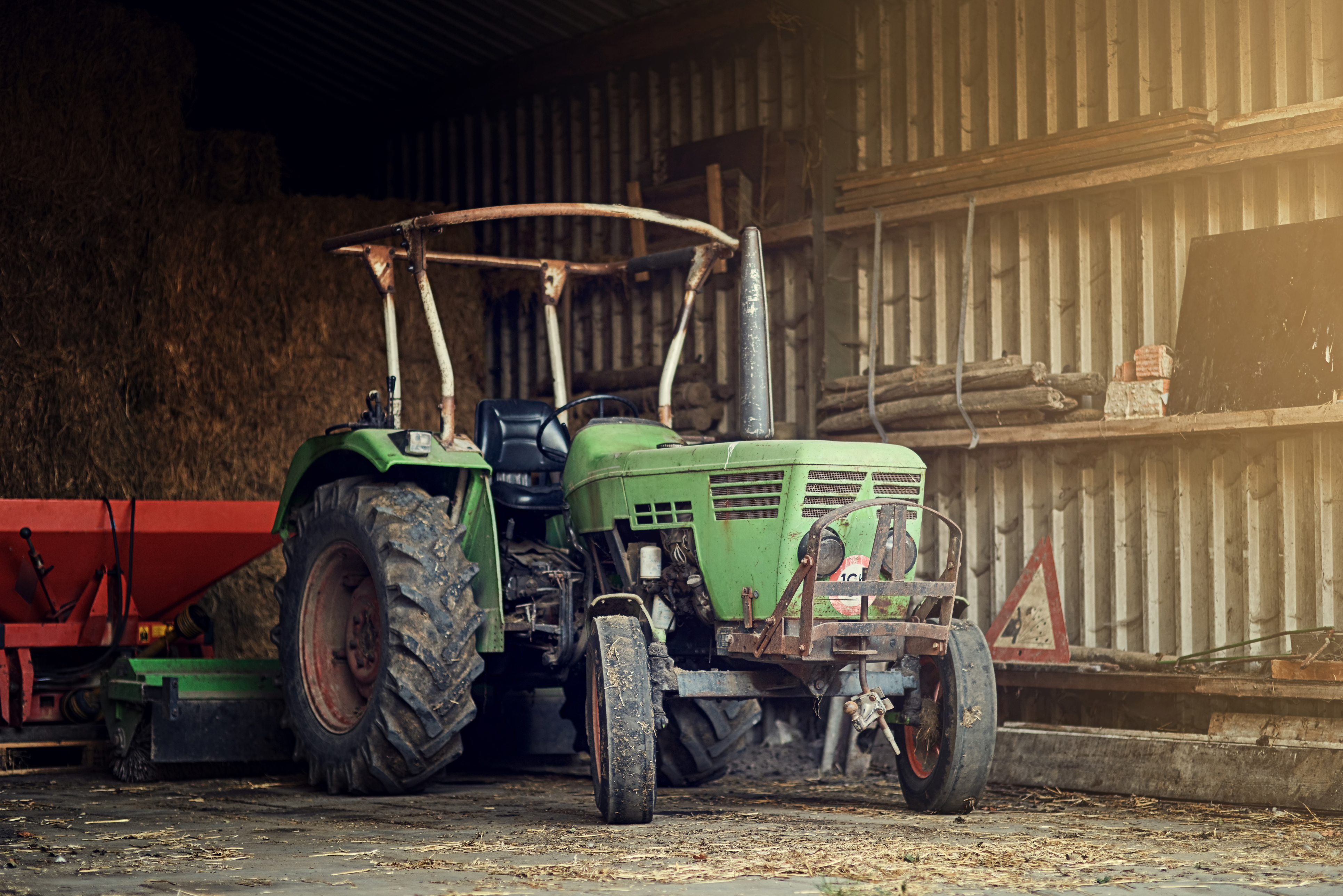 Gammel grøn traktor i lade