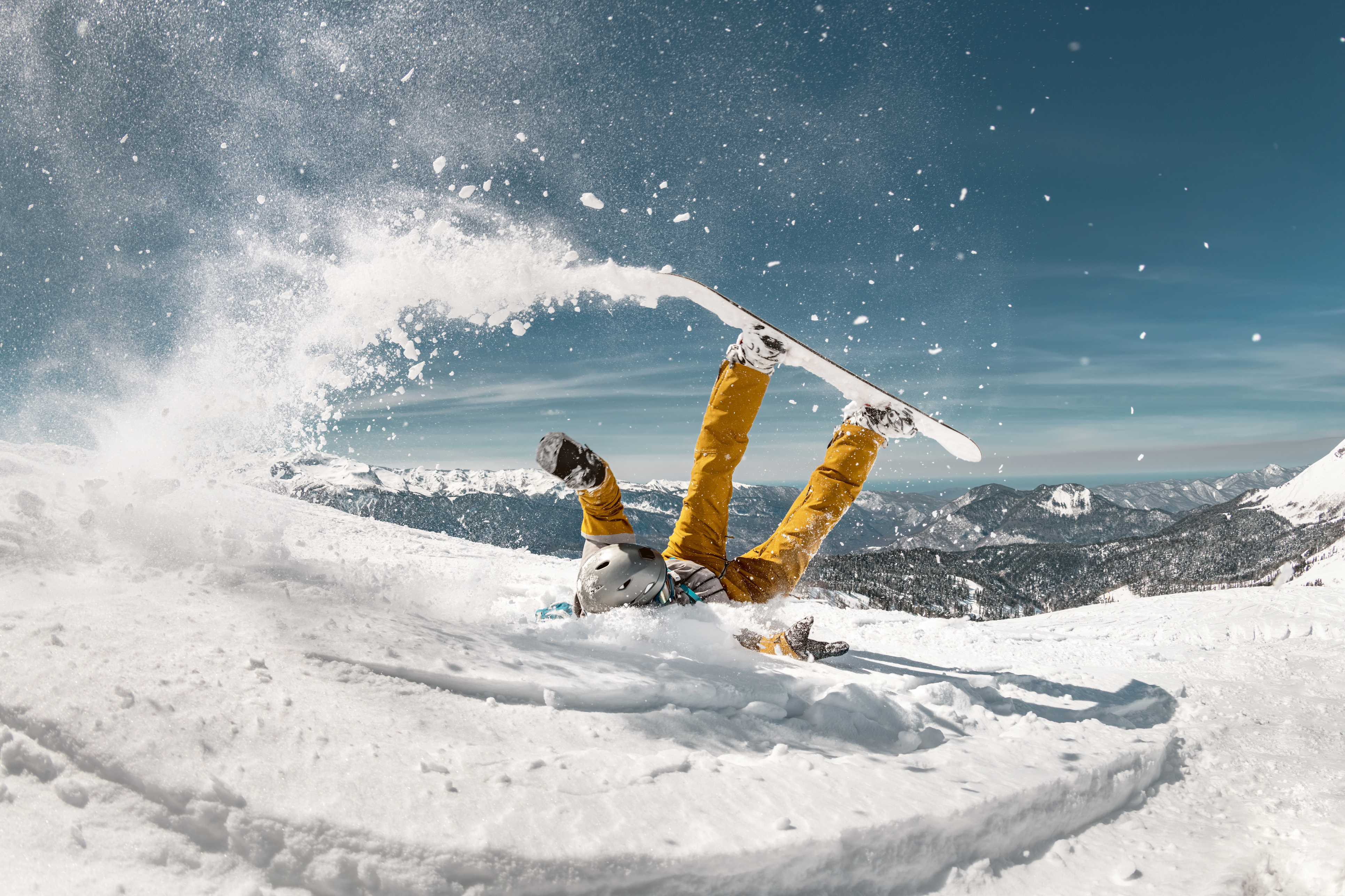 En snowboarder, der lander på ryggen i sneen