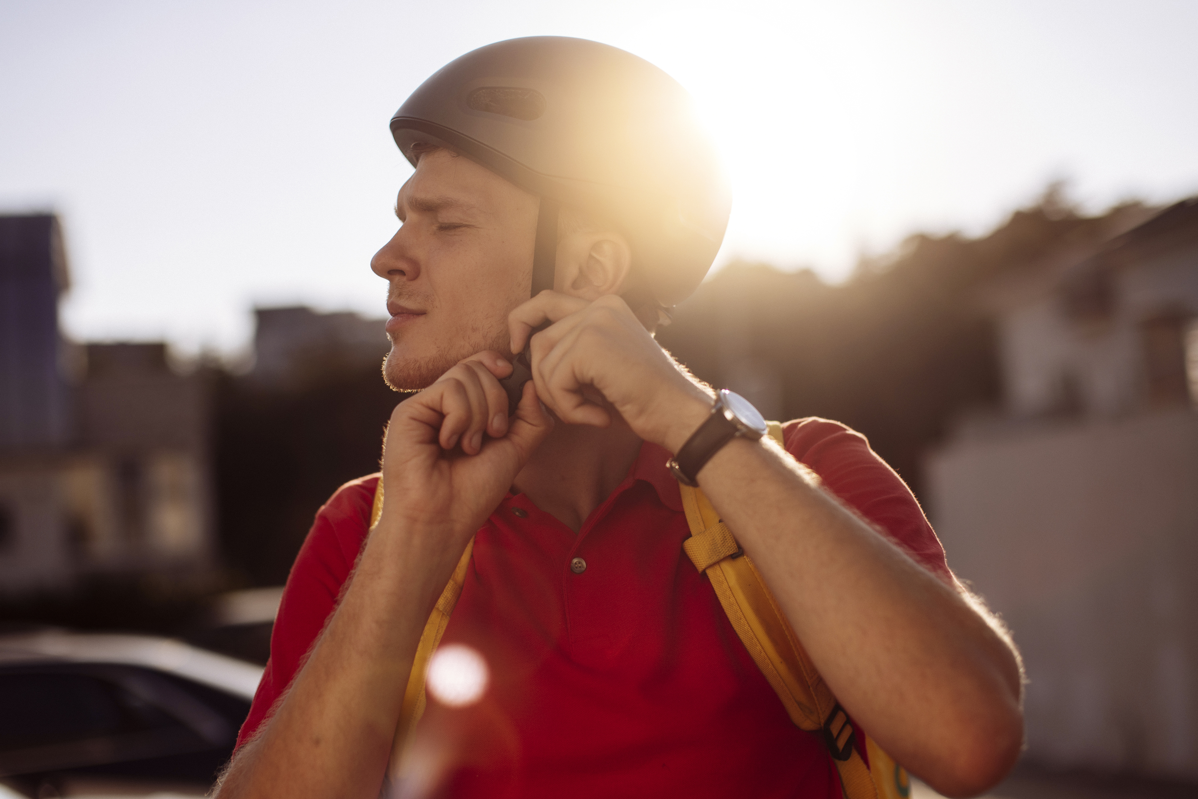 En ung mand, der spænder sin cykelhjelm