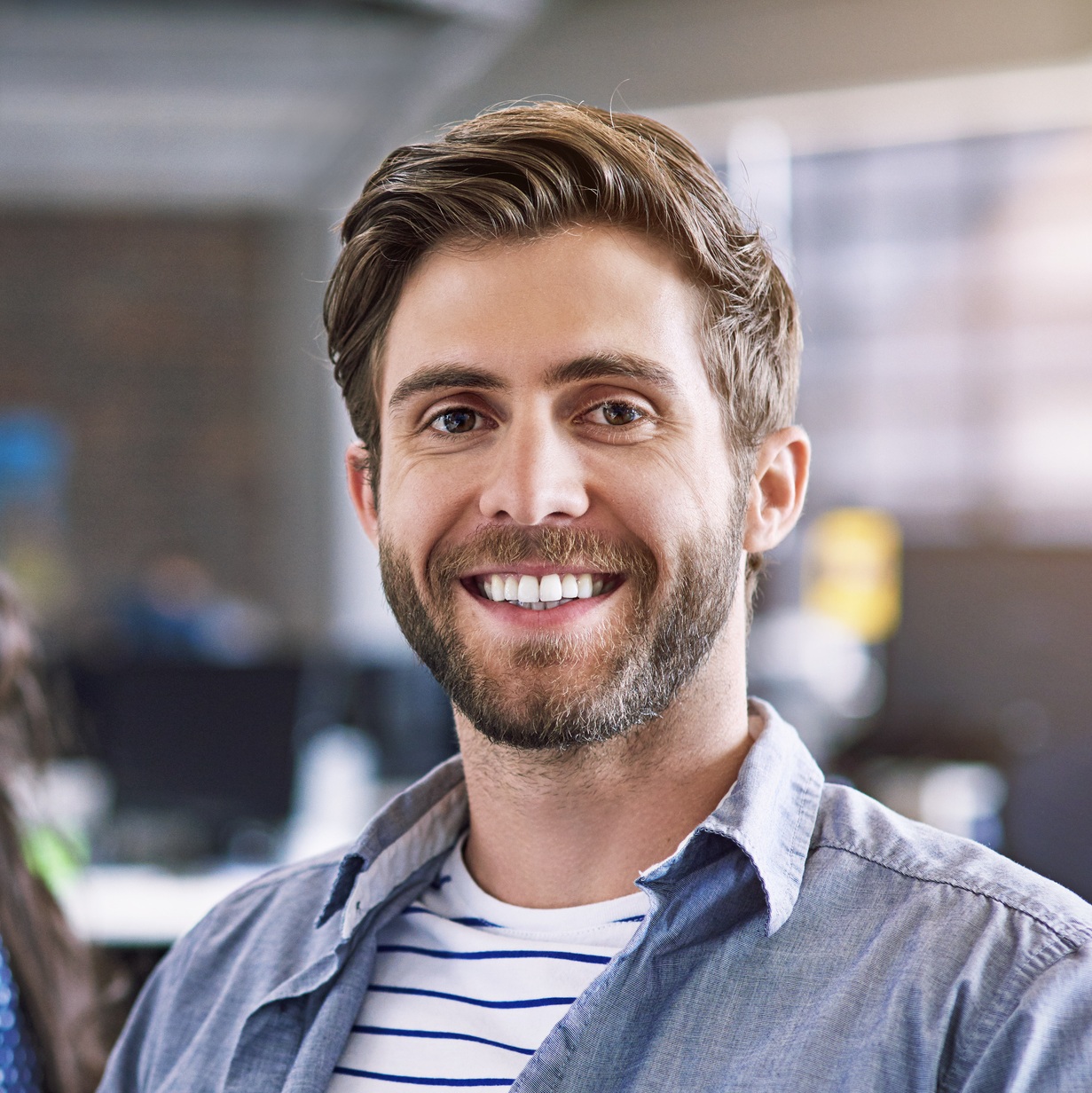 Mand, der sidder på arbejdet og smiler